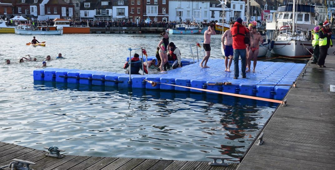Swimmers in water approaching a Pontoonworks floating platform solution