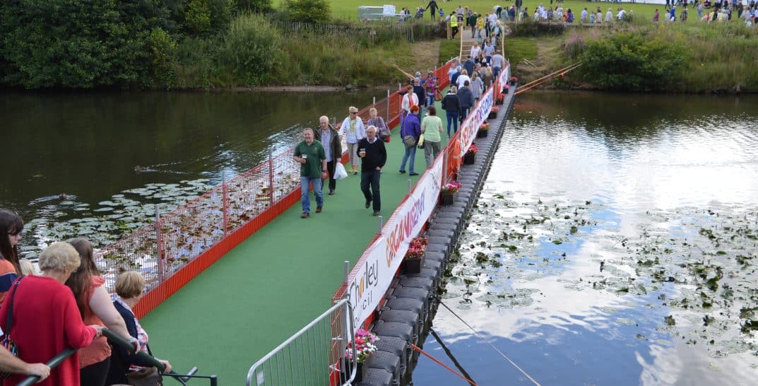 Floating pontoon used as a platform bridge with people walking across a river